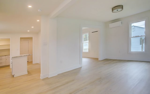spare room with light wood finished floors, recessed lighting, and a wall unit AC