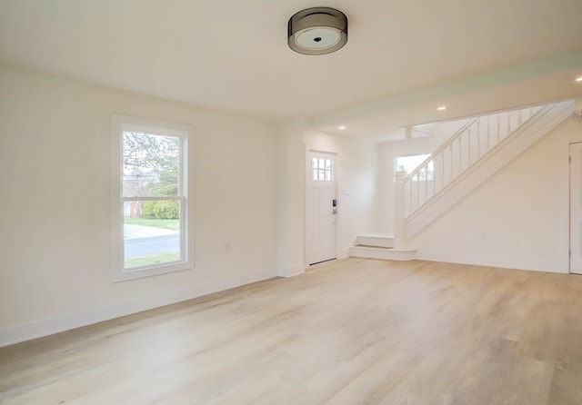interior space with light wood-type flooring, a healthy amount of sunlight, and stairway