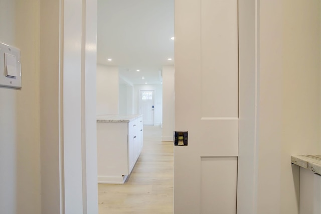 hall featuring light wood-style flooring, baseboards, and recessed lighting