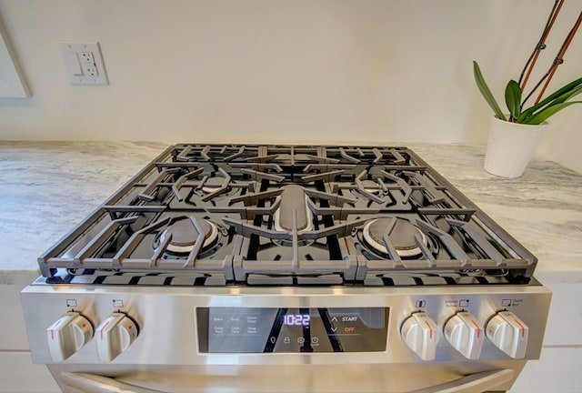 interior details featuring stone counters and stainless steel gas stove