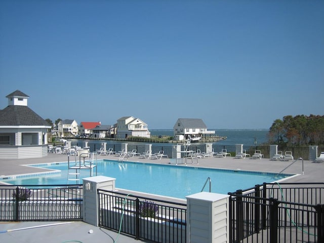 view of swimming pool featuring a patio area and a water view