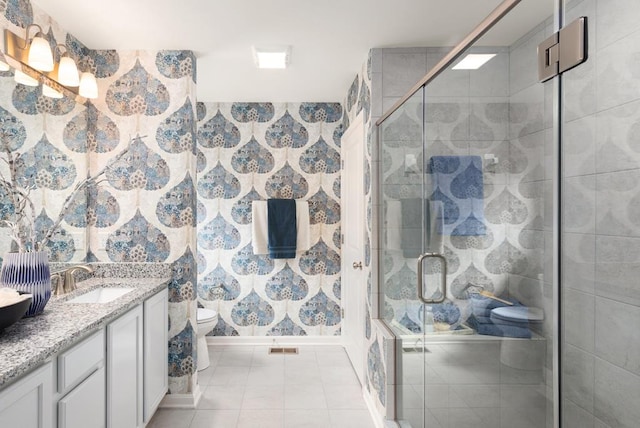 bathroom with tile patterned floors, vanity, toilet, and walk in shower