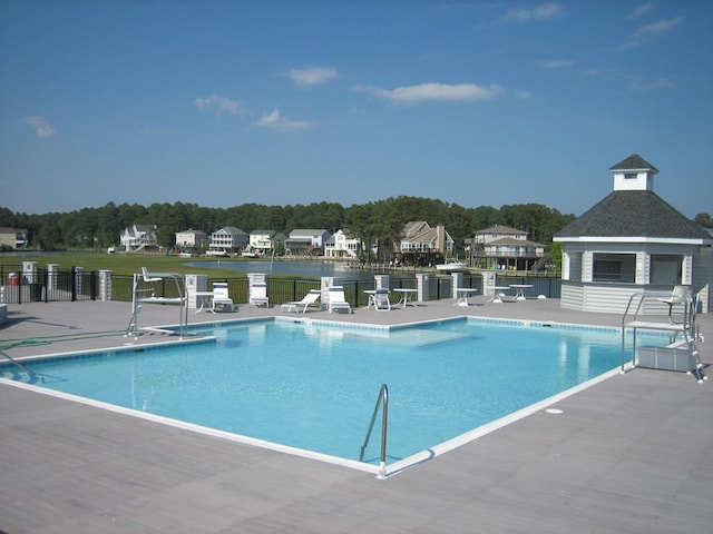 view of swimming pool with a patio and a water view