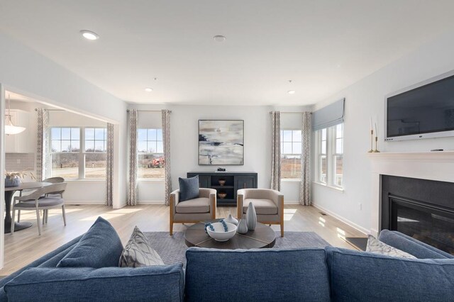 547 Skipper Ct, Greenbackville, VA 23356 - living area with plenty of natural light, light wood finished floors, a glass covered fireplace, and recessed lighting