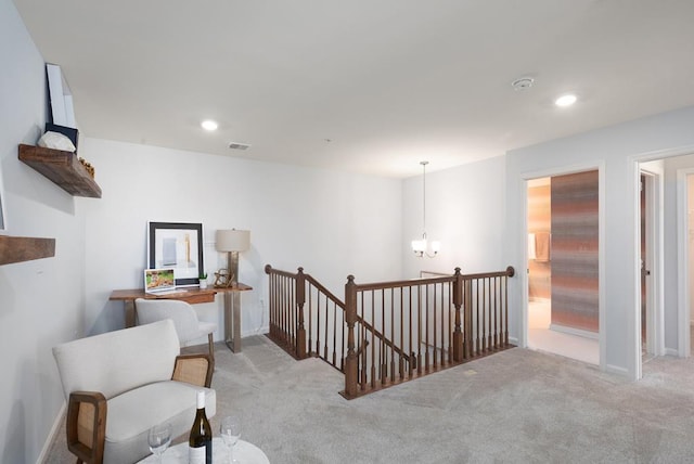 living area with light carpet and an inviting chandelier