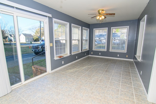 unfurnished sunroom featuring ceiling fan