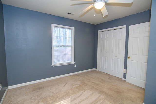 unfurnished bedroom featuring a closet, ceiling fan, and light colored carpet