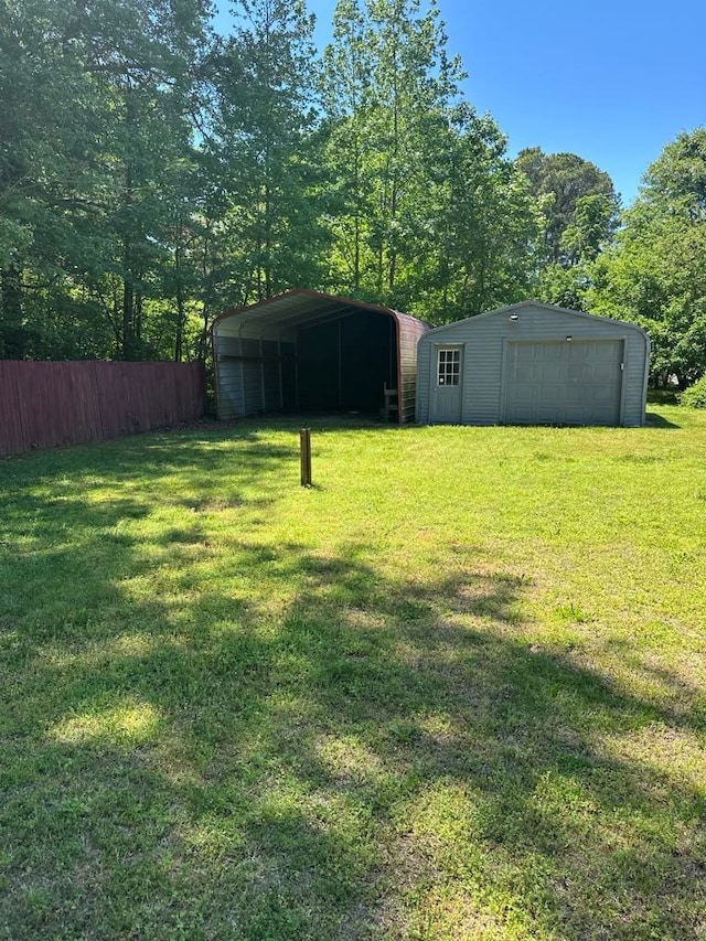 12196 Tower Way, Exmore, VA 23350 - view of yard featuring an outbuilding, a carport, fence, and a detached garage