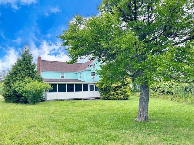 3250 Colona St, Chincoteague, VA 23336 - rear view of property with a sunroom, a chimney, a yard, and a shingled roof
