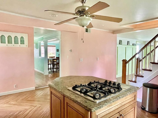 3250 Colona St, Chincoteague, VA 23336 - kitchen featuring stainless steel gas cooktop, ceiling fan, baseboards, crown molding, and brown cabinets
