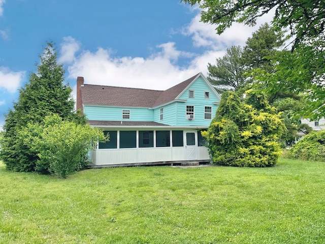 3250 Colona St, Chincoteague, VA 23336 - rear view of property featuring a sunroom, a chimney, a lawn, and roof with shingles