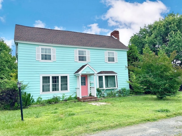 3250 Colona St, Chincoteague, VA 23336 - colonial-style house with a chimney, a front lawn, and a shingled roof