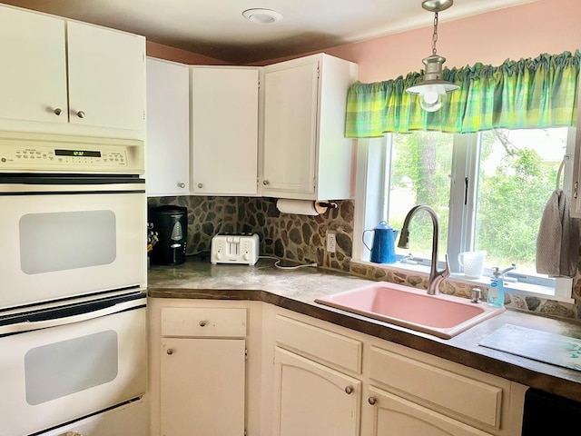 3250 Colona St, Chincoteague, VA 23336 - kitchen featuring double oven, a sink, tasteful backsplash, white cabinetry, and decorative light fixtures