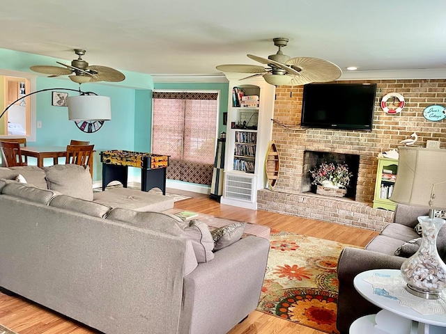 3250 Colona St, Chincoteague, VA 23336 - living room with ceiling fan, wood finished floors, a brick fireplace, and ornamental molding