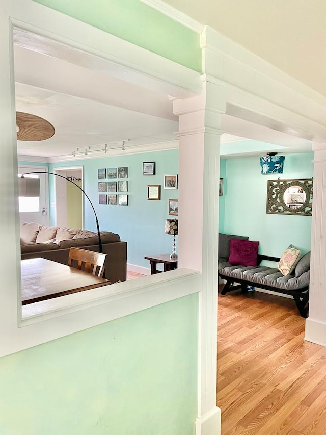 3250 Colona St, Chincoteague, VA 23336 - hallway with ornate columns, wood finished floors, rail lighting, and baseboards