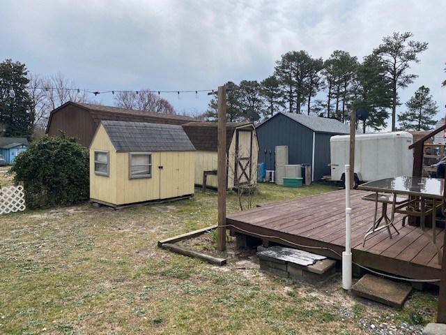 exterior space with a yard, an outdoor structure, outdoor dining space, and a shed