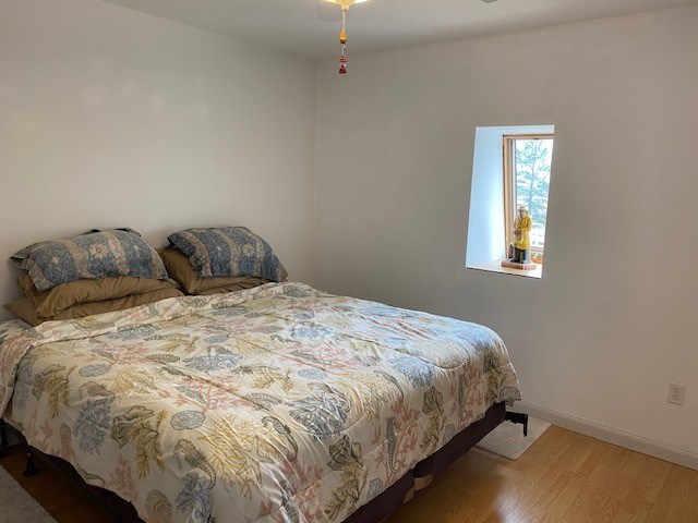 bedroom with wood finished floors and baseboards