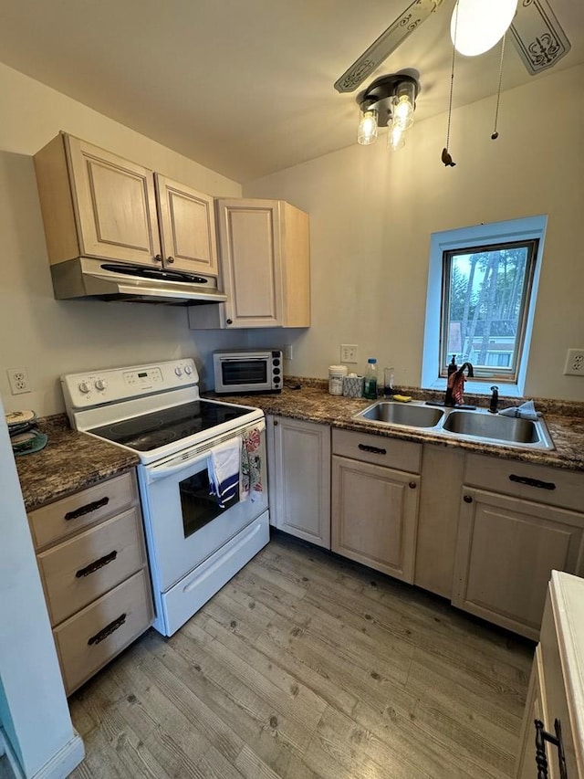 kitchen featuring light wood-style flooring, white range with electric cooktop, under cabinet range hood, a sink, and dark countertops