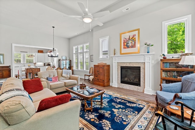 8 Perny Ct, Cape Charles, VA 23310 - living area with baseboards, a glass covered fireplace, visible vents, ceiling fan with notable chandelier, and wood finished floors