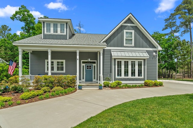 8 Perny Ct, Cape Charles, VA 23310 - view of front of home featuring board and batten siding, a standing seam roof, fence, covered porch, and a shingled roof