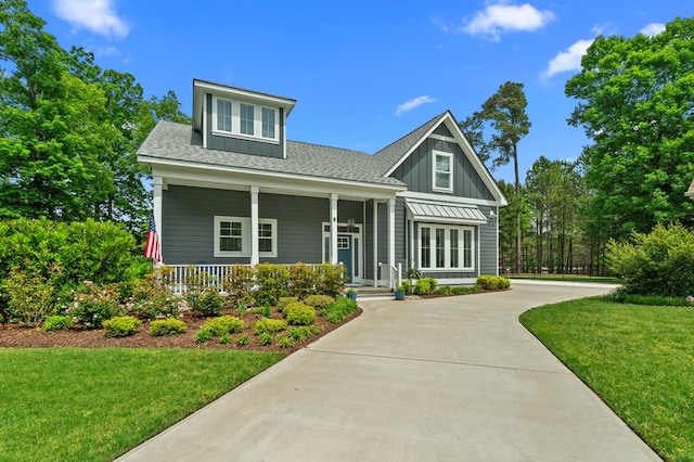 8 Perny Ct, Cape Charles, VA 23310 - craftsman-style home with covered porch, a shingled roof, a front lawn, and board and batten siding