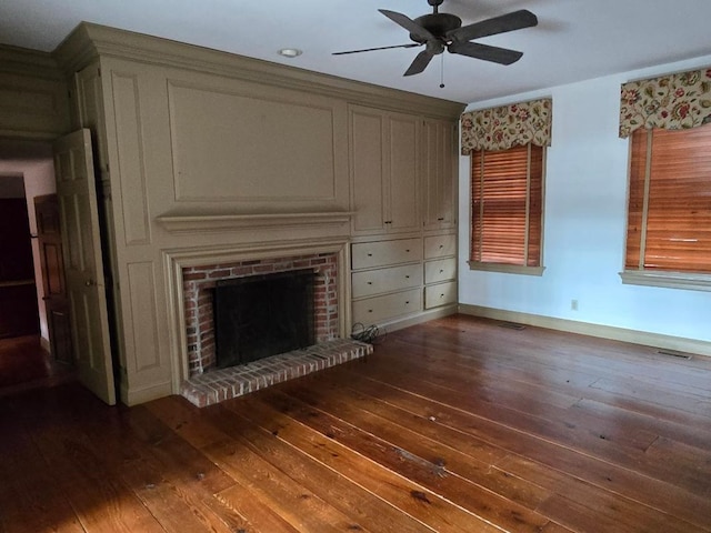 unfurnished living room featuring visible vents, baseboards, a ceiling fan, wood-type flooring, and a brick fireplace