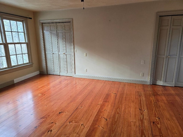 unfurnished bedroom with light wood-type flooring and baseboards