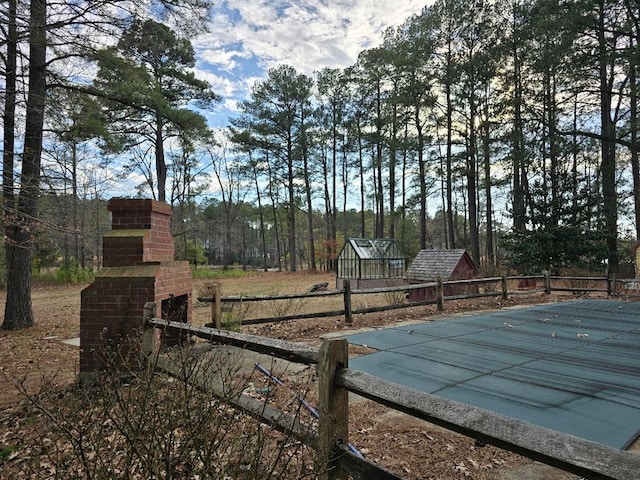 view of yard with an outbuilding, fence, and a fenced in pool