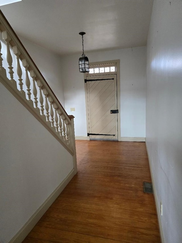 interior space with visible vents, stairs, baseboards, and wood finished floors