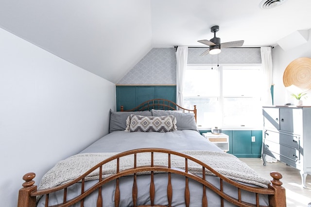 bedroom featuring ceiling fan, hardwood / wood-style floors, and vaulted ceiling