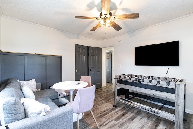 living room with hardwood / wood-style flooring, ceiling fan, ornamental molding, and a textured ceiling