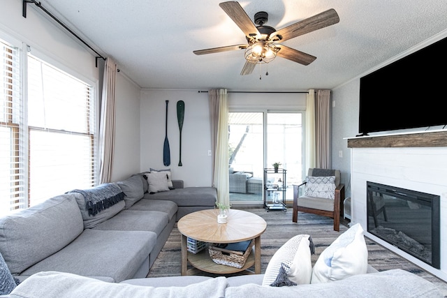 living room with hardwood / wood-style flooring, plenty of natural light, ceiling fan, and a textured ceiling