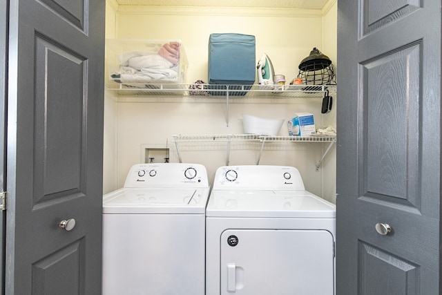 clothes washing area featuring washer and dryer and ornamental molding