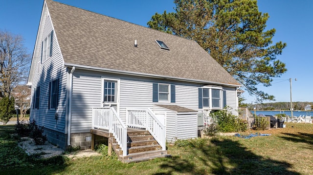 back of house featuring a yard and a water view