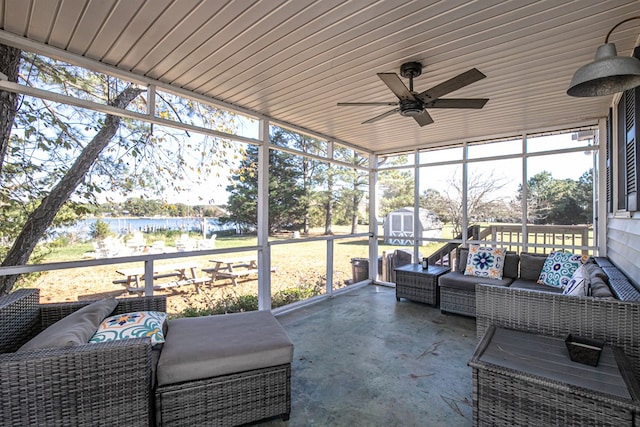 sunroom featuring a water view and ceiling fan