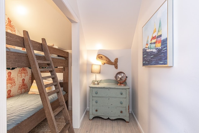 bedroom with light hardwood / wood-style flooring and lofted ceiling