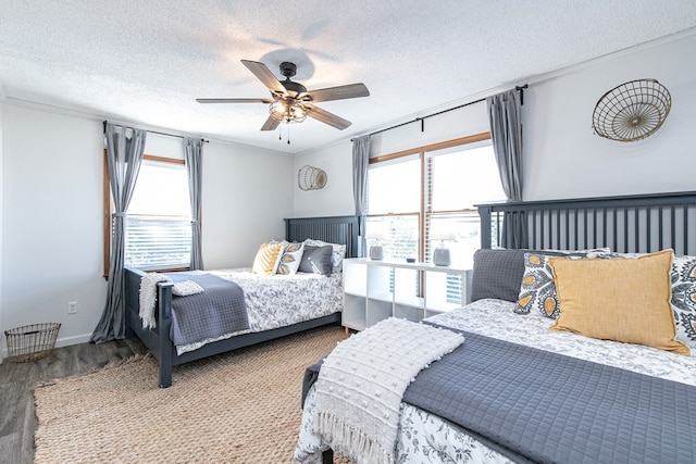 bedroom with ceiling fan, hardwood / wood-style floors, and a textured ceiling