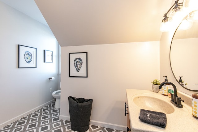 bathroom with tile patterned floors, vanity, vaulted ceiling, and toilet