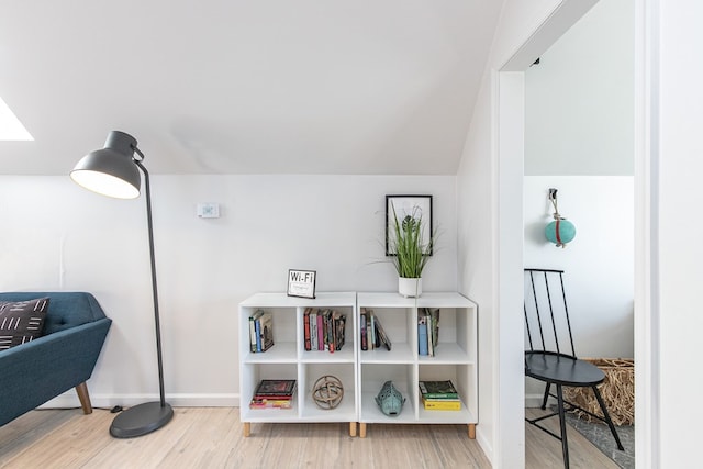 sitting room featuring wood-type flooring and vaulted ceiling