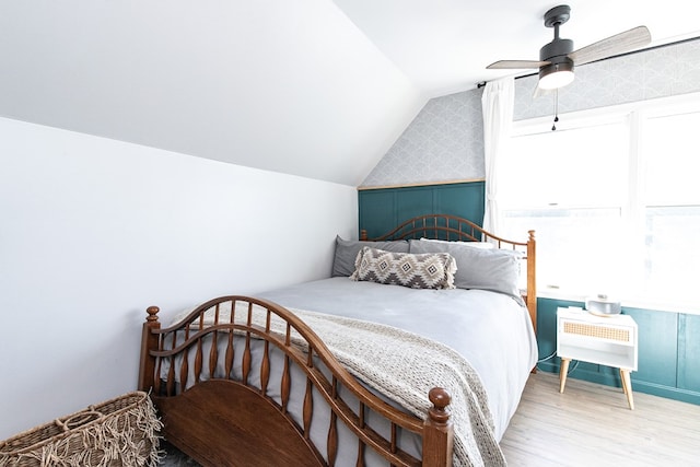 bedroom featuring ceiling fan, light wood-type flooring, and vaulted ceiling