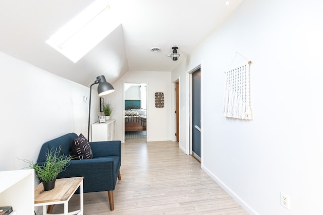 hall with light hardwood / wood-style floors and vaulted ceiling