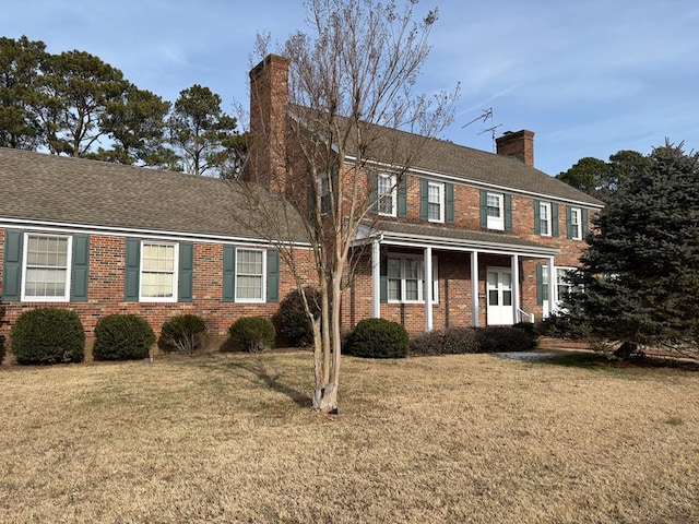 colonial-style house featuring a front lawn