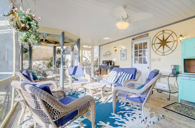 sunroom featuring ceiling fan and wood ceiling