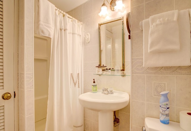 bathroom featuring a shower with shower curtain, sink, toilet, and tile walls