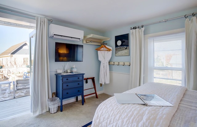 bedroom with access to exterior, light colored carpet, and an AC wall unit