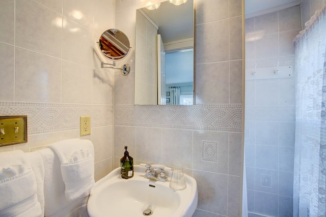 bathroom featuring tile walls and sink