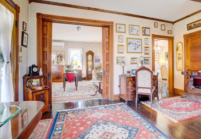 interior space featuring dark hardwood / wood-style floors, ornamental molding, a wall mounted AC, and a chandelier