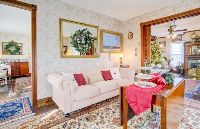 living room with a fireplace, wood-type flooring, and ceiling fan