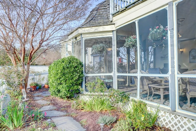 view of side of home with a sunroom and a balcony