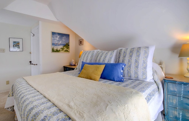 carpeted bedroom with lofted ceiling